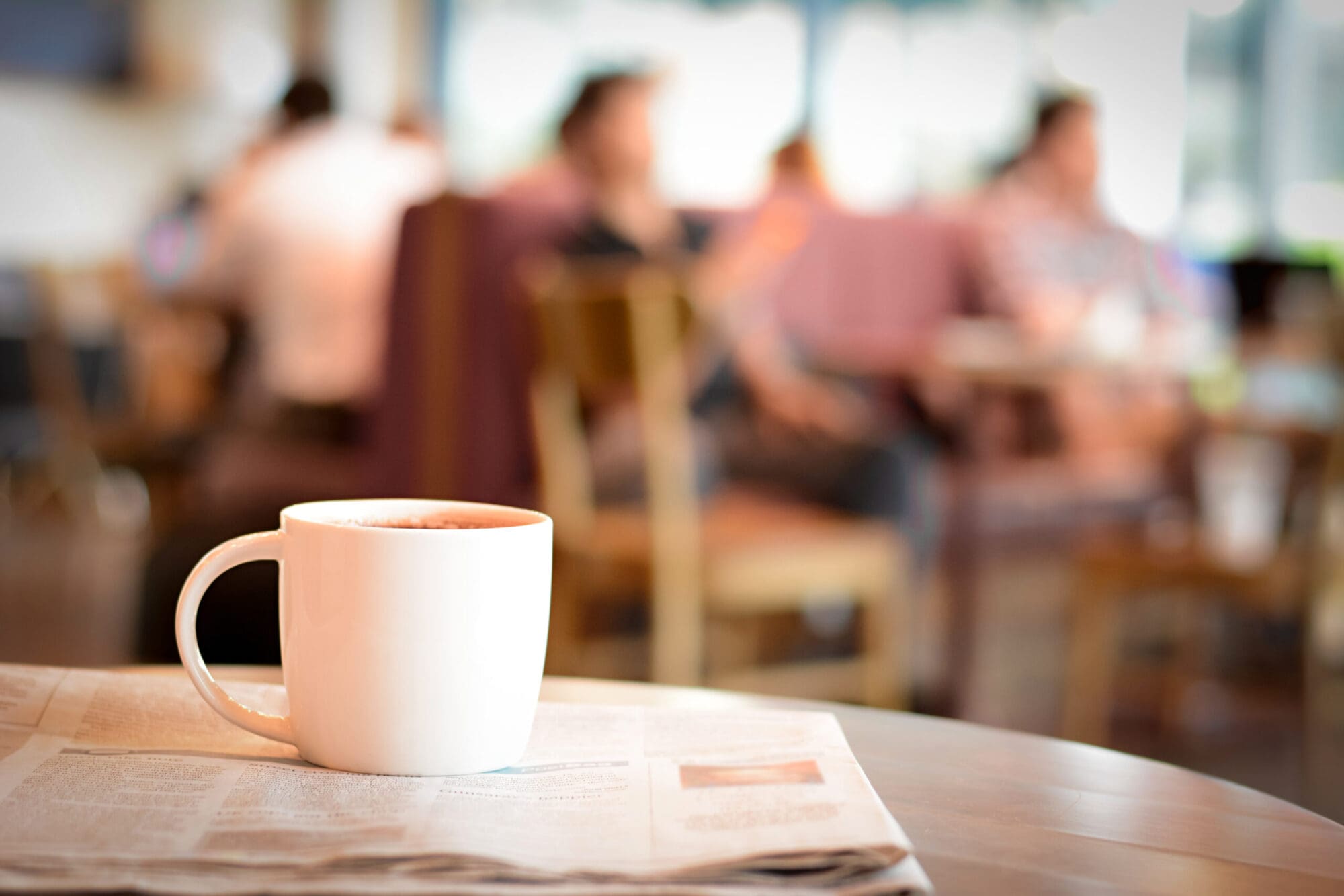 White coffee cup on newspaper in café setting